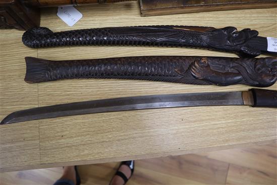 Two 19th century Japanese swords the wood scabbards, carved as a dragon and a merman longest 67cm